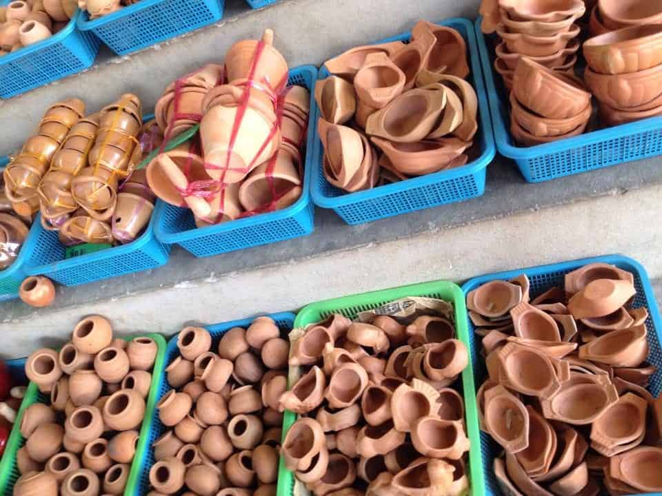Clay pottery sitting in colorful baskets at the market in Koh Kret, Thailand.
