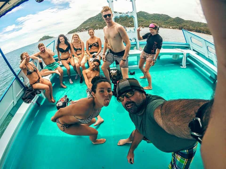 Scuba diving instructor, divemaster and students take a selfie on a dive boat.