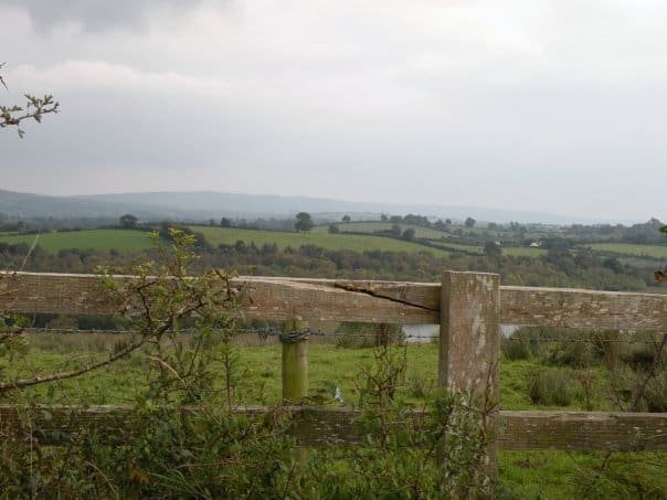 A weathered fence in County Monaghan with rolling green hills in the background.