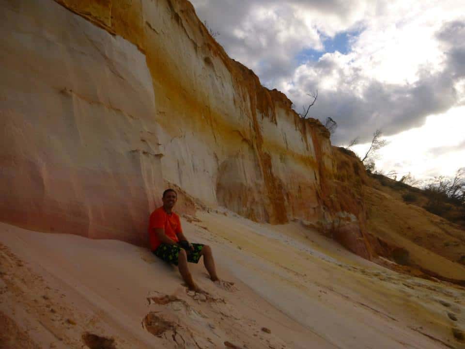 Dropbear Adventures tour guide sitting on the beach on K'Gari island.