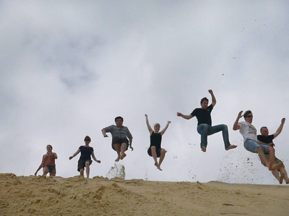 3-day K'gari island tour participants playing in the sand dunes.
