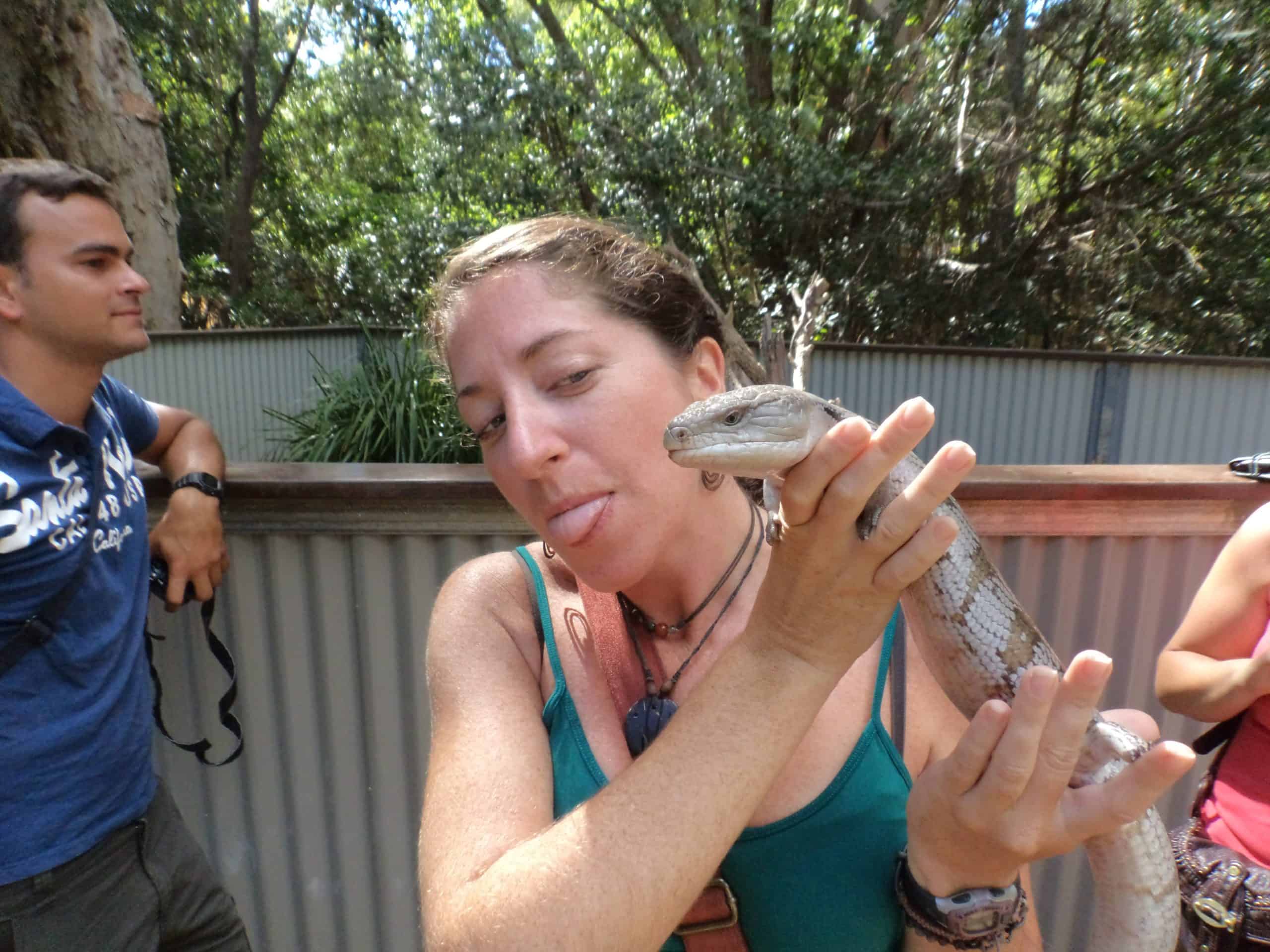 Woman holds a lizard at a wildlife park on Magnetic Island.