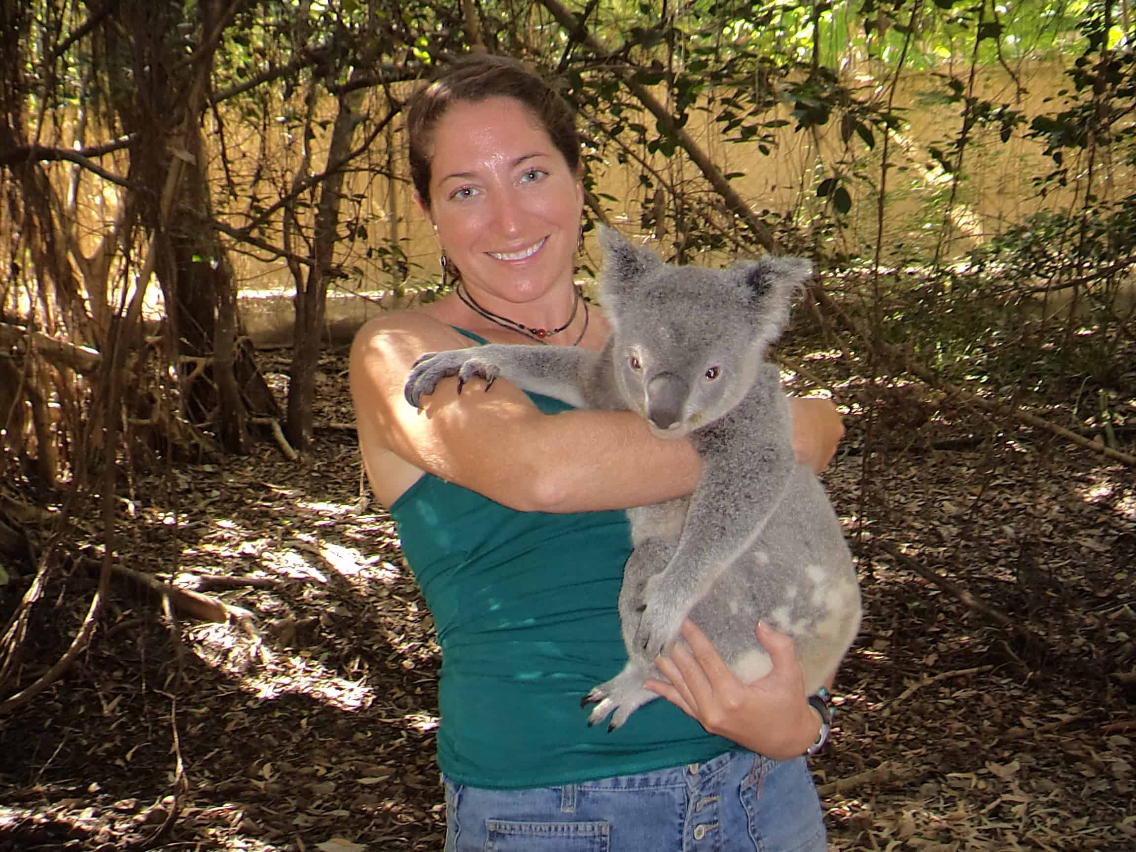 Woman holds a Koala on Maggie Island in Australia.