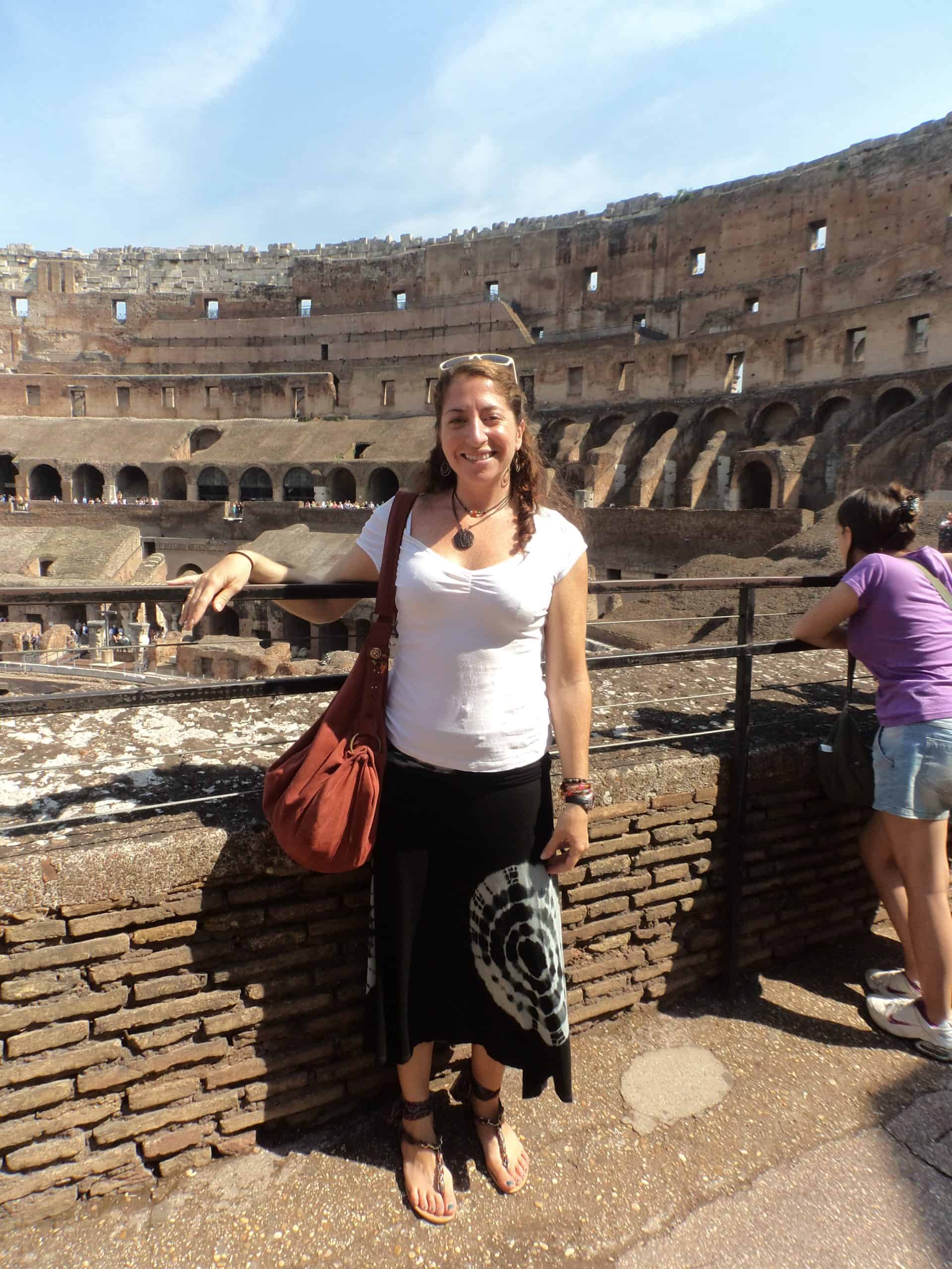 Woman poses inside the Colosseum in Rome.