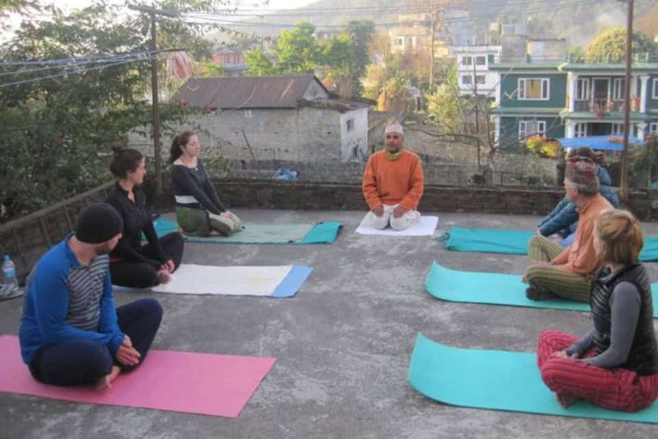 Group of trekkers enjoying roof top yoga in Pokhara after their Annapurna Circuit trek.