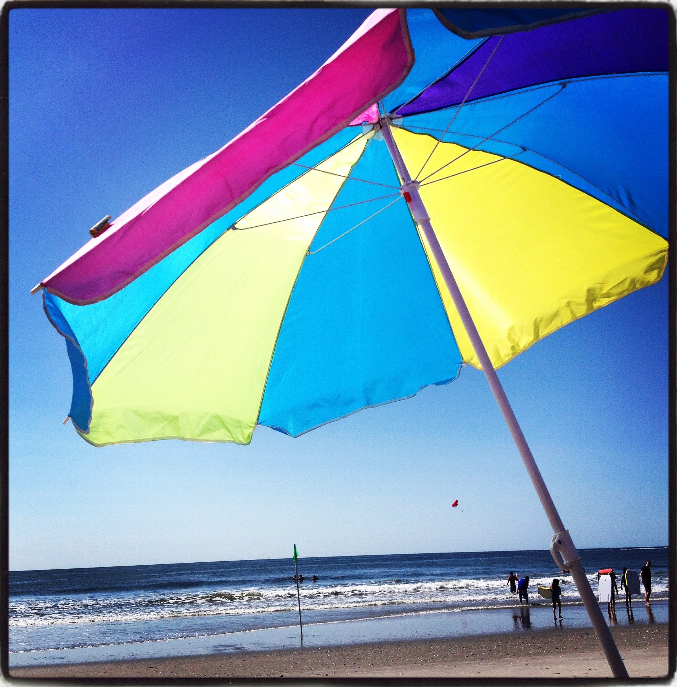 A colorful umbrella in the sand at the Ocean City, NJ beach.