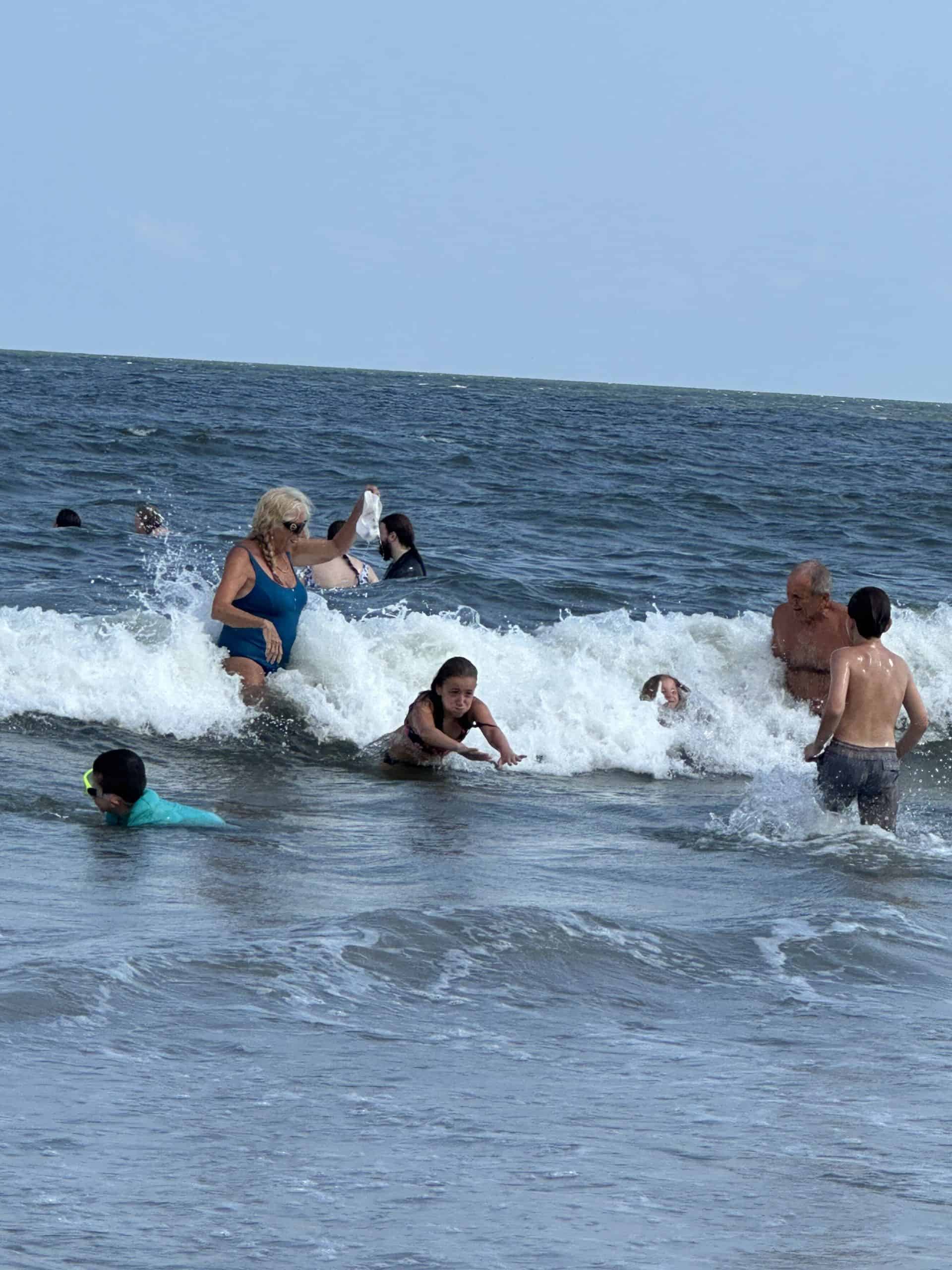 Visitors to Ocean City, NJ play in the waves.