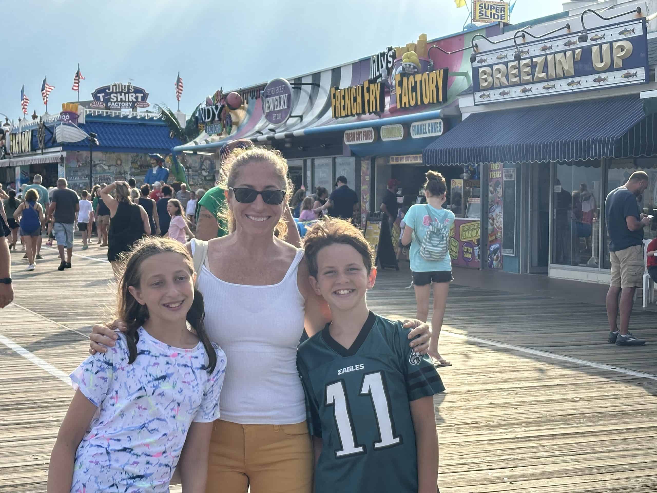 A woman and two children pose for a picture on the Ocean City, NJ boardwalk.