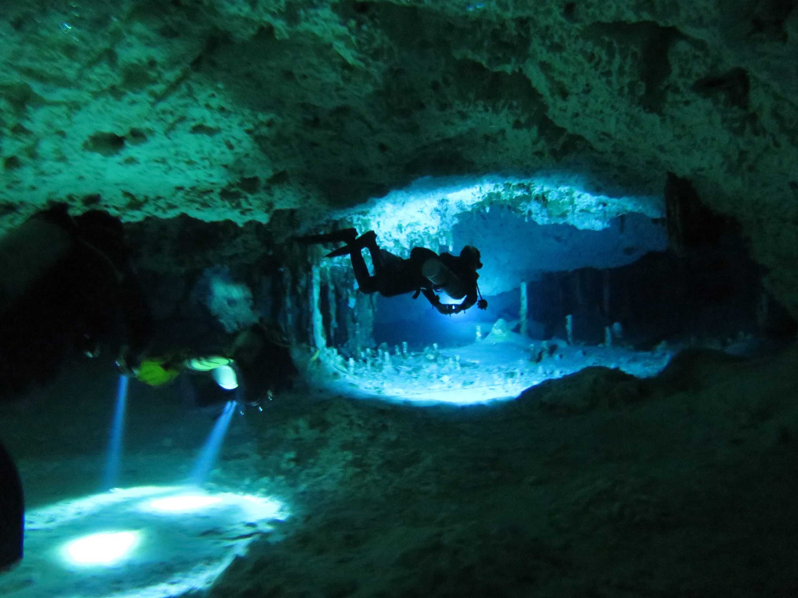 Two divers explore the Dos Ojos cenote in Tulum, Mexico.