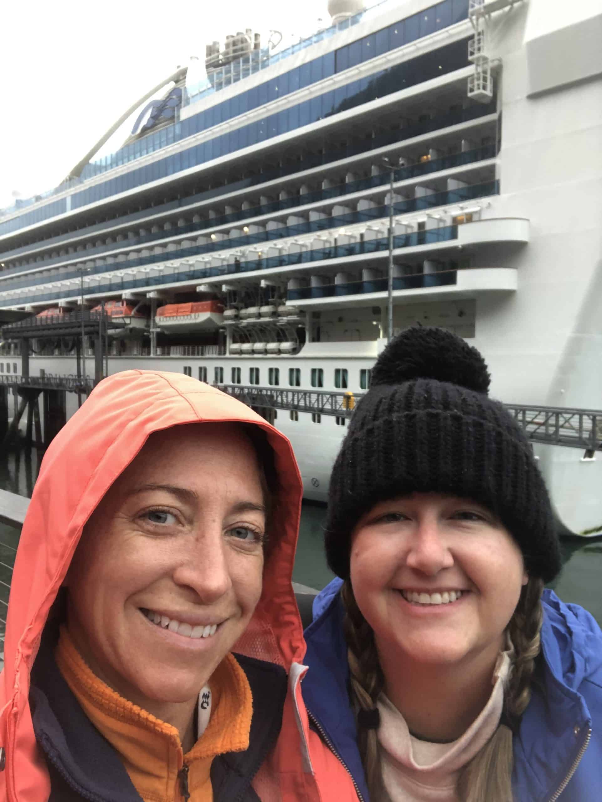 Two women bundled up standing in front of the Sapphire Princess cruise ship in Whittier, Alaska.