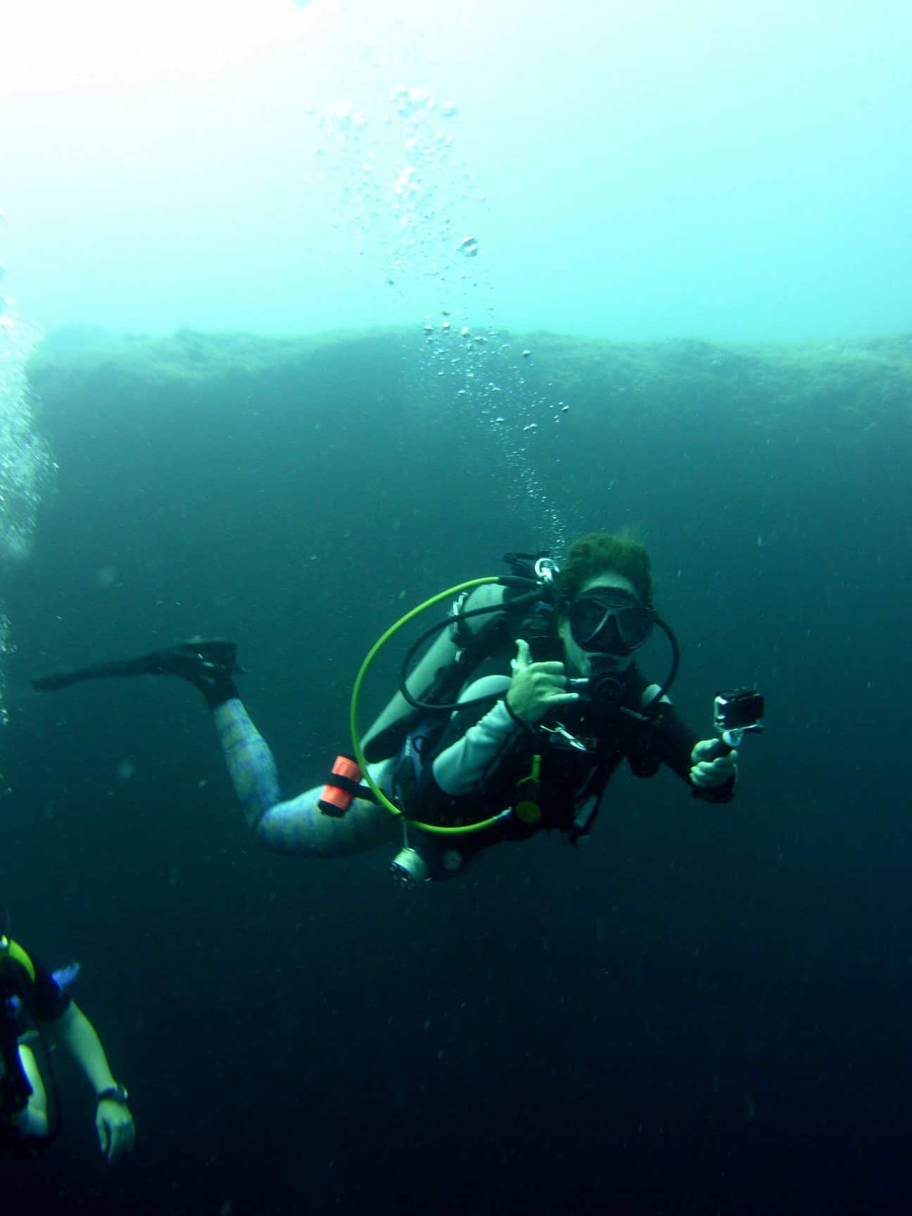 A diver descends into the depths of the ocean from a liveaboard dive vessel.