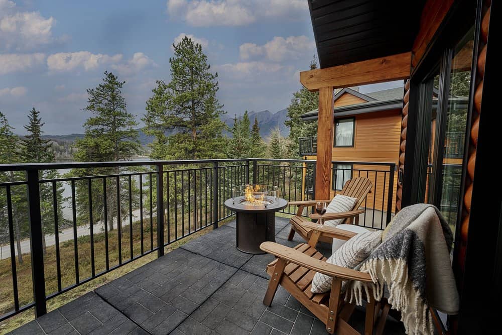 A cozy and romantic setting complete with a fire pit, fur-lined Adirondack chairs and a lake view from a private balcony at the Lake Pyramid Lodge in Jasper, Canada.