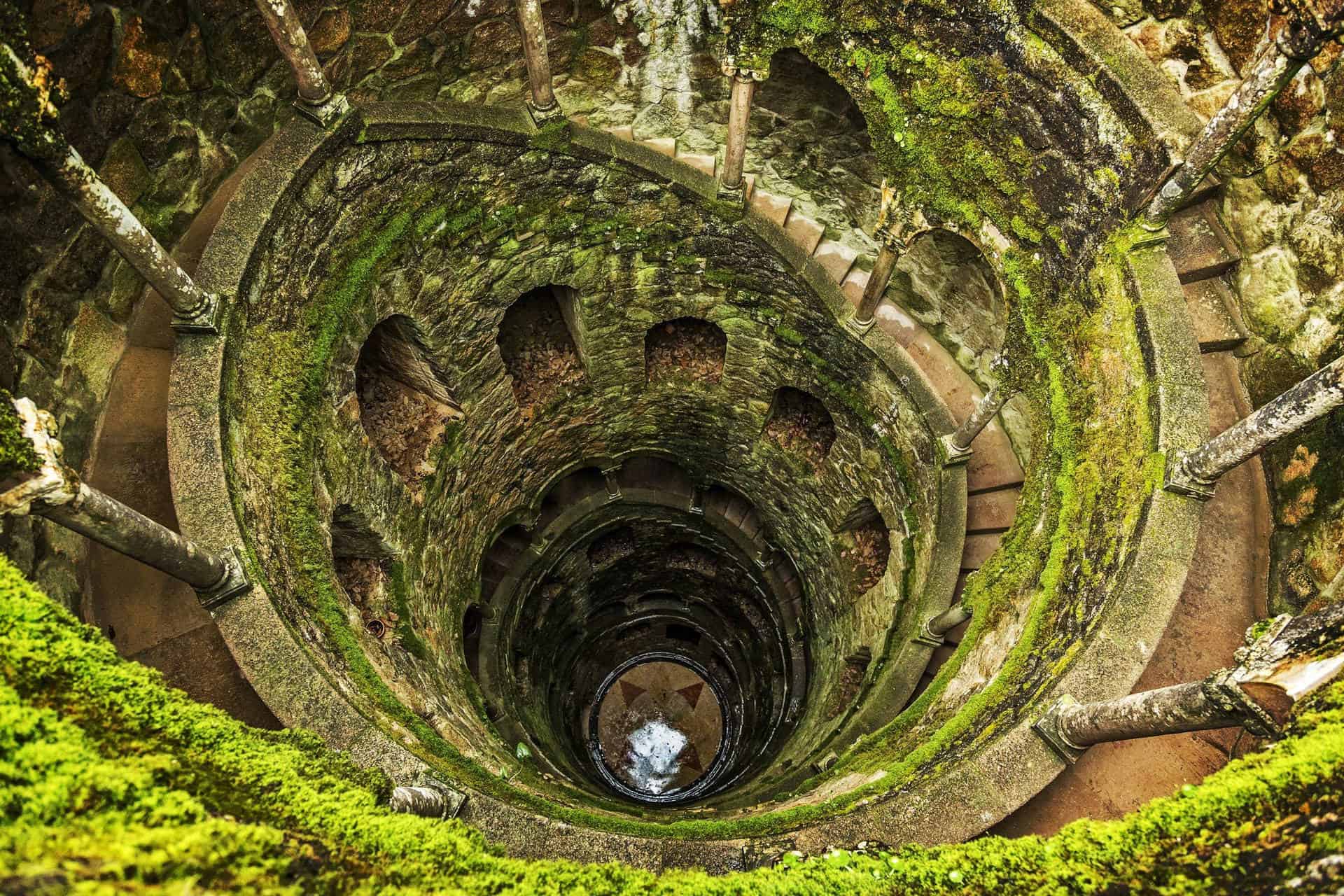 Moss-covered spiraled staircase at Quinta da Regaleira Sintra.