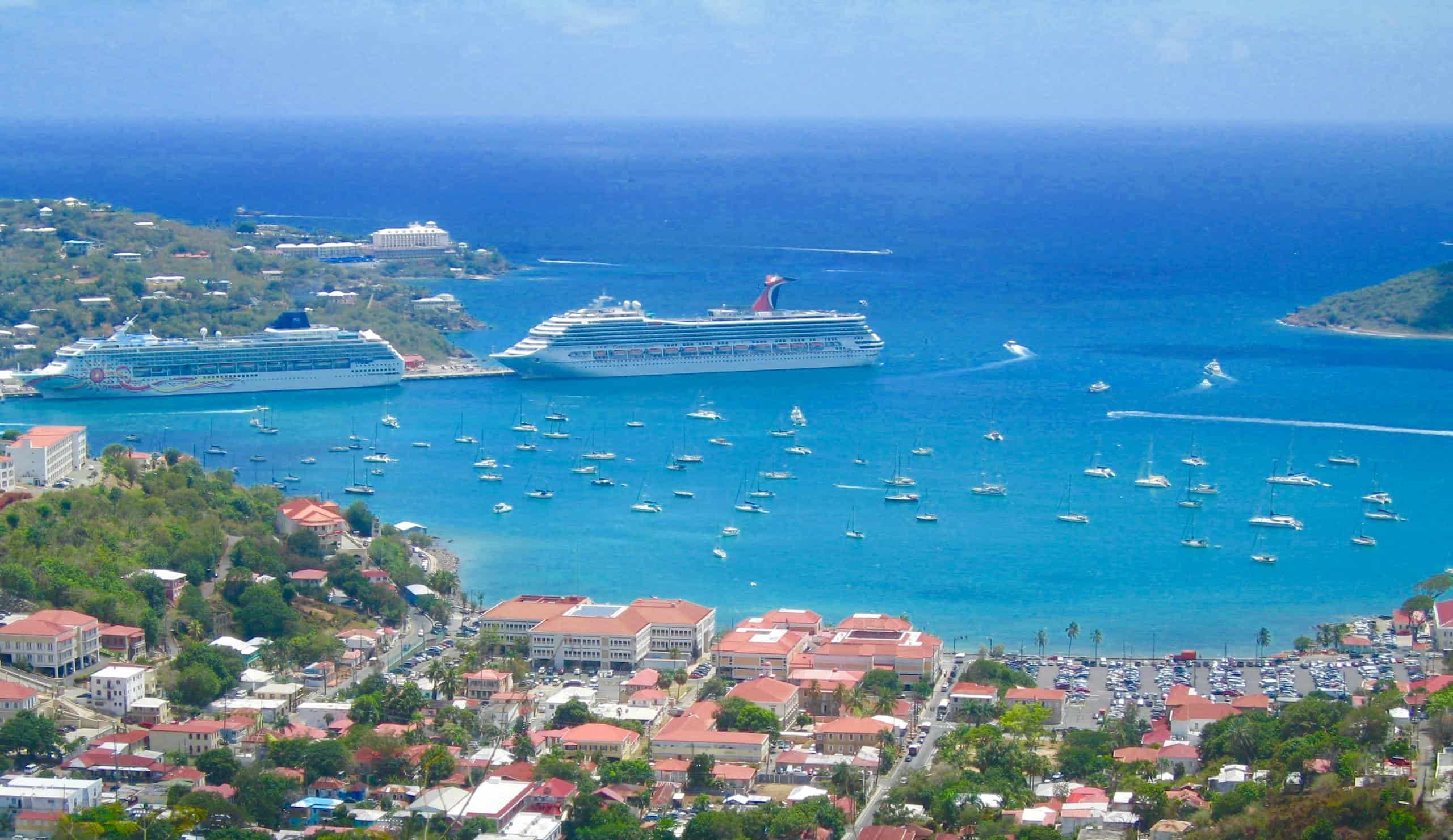 Scenic aerial view of a tropical harbor in the Eastern Caribbean with cruise ships and sailboats in clear blue waters.