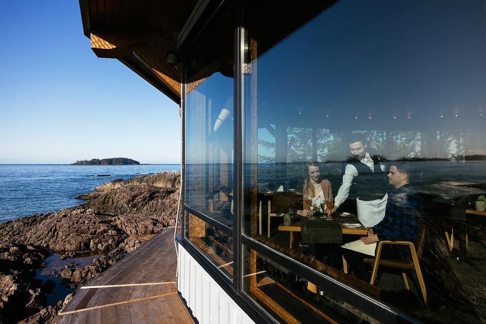 A couple enjoys a romantic dinner with sea views at the Wickaninnish Inn in Vancouver, Canada.