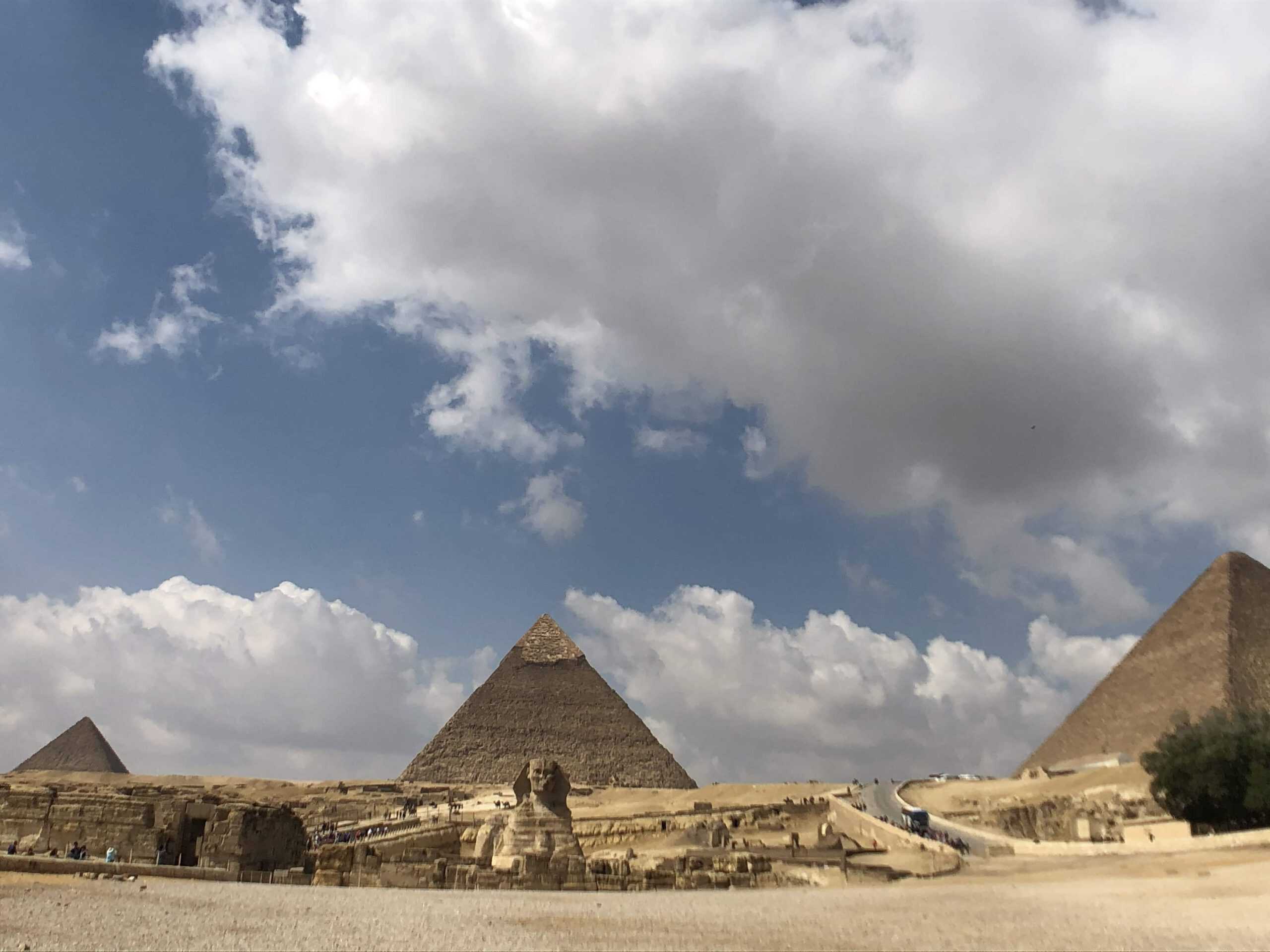 The Sphinx with the 3 Great Pyramids of Giza in the background.