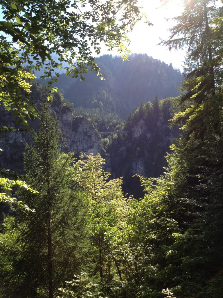 A view of Marienbrücke from Neuschwanstein Castle through the mountain foliage.