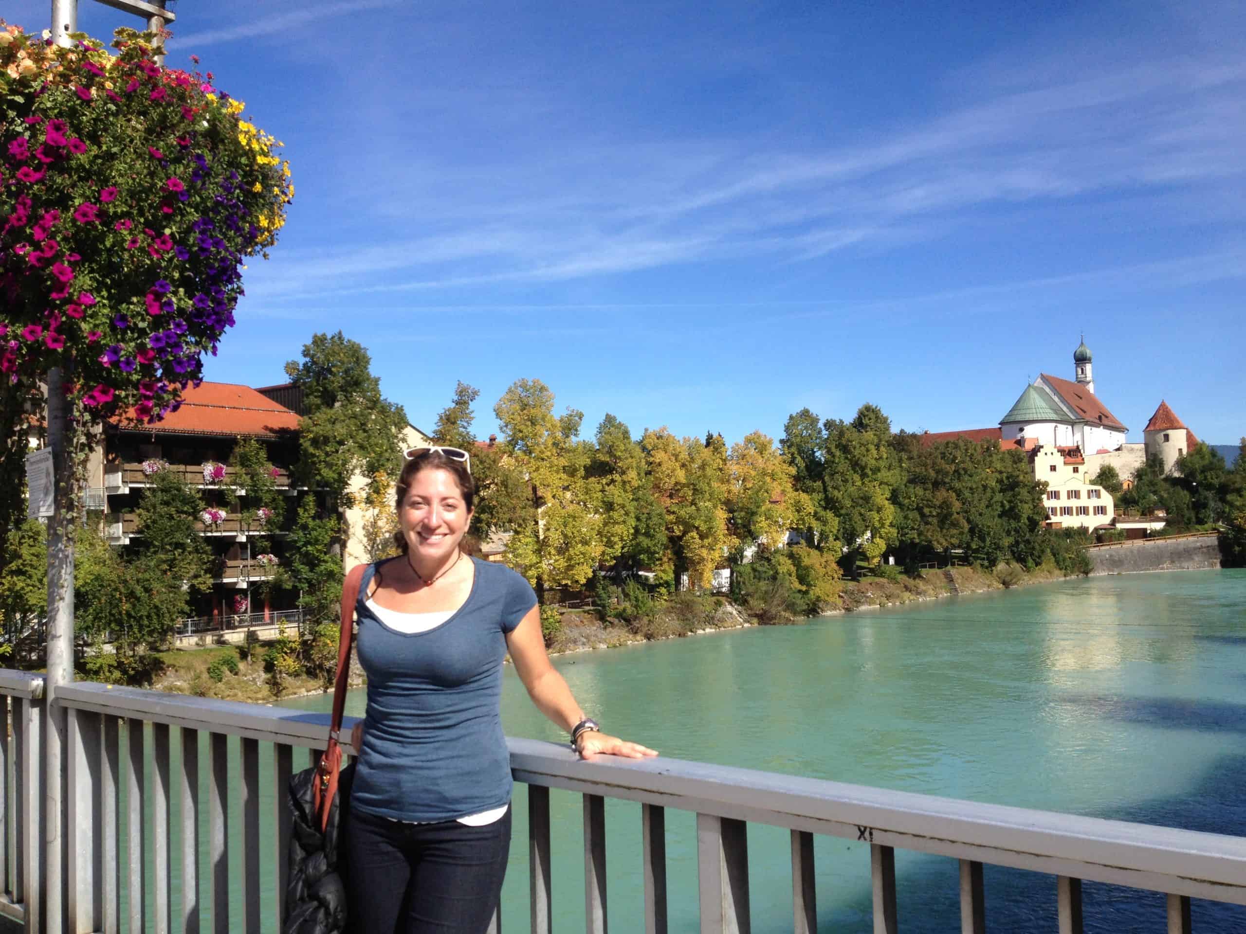 Woman posing on a bridge over the Lech River in Füssen, Germany.