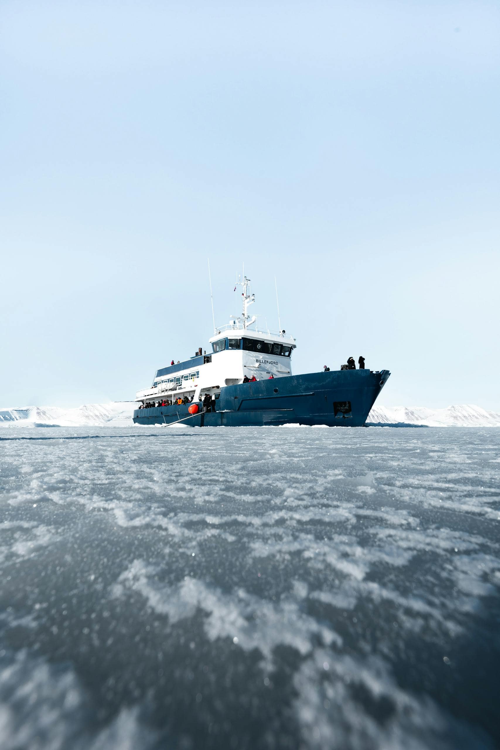 A large icebreaker navigates through icy Arctic waters, showcasing polar travel.