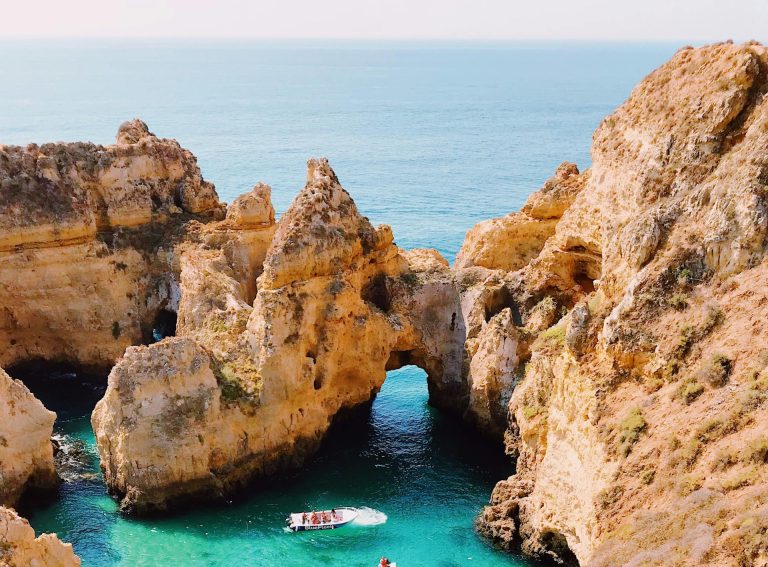 Stunning aerial view of cliffs and clear blue water at Lagos, Portugal, showcasing natural beauty.