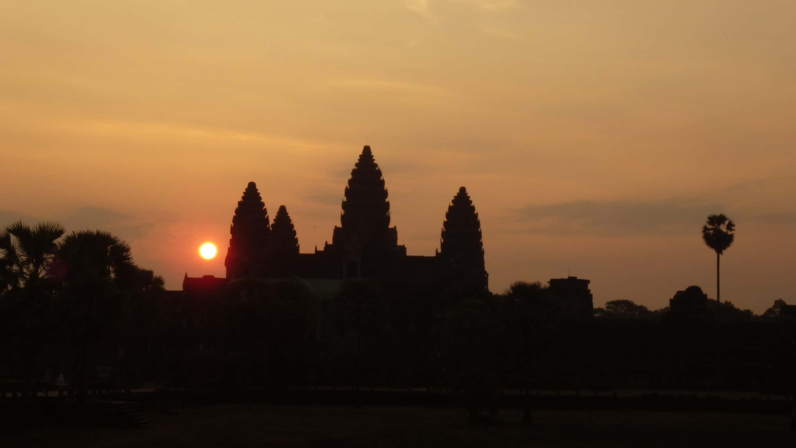 Sun rising over the temple ruins at Angkor Wat.