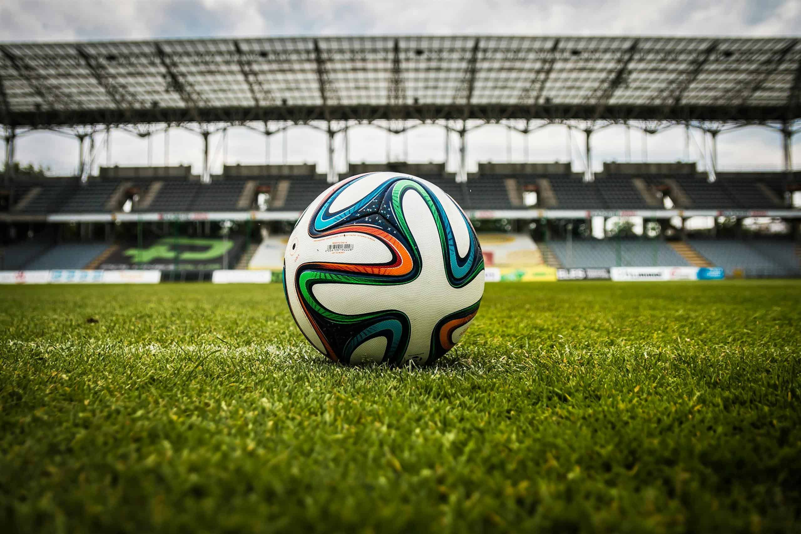 A vibrant soccer ball rests on a lush green field inside MetLife stadium before the 2026 World Cup