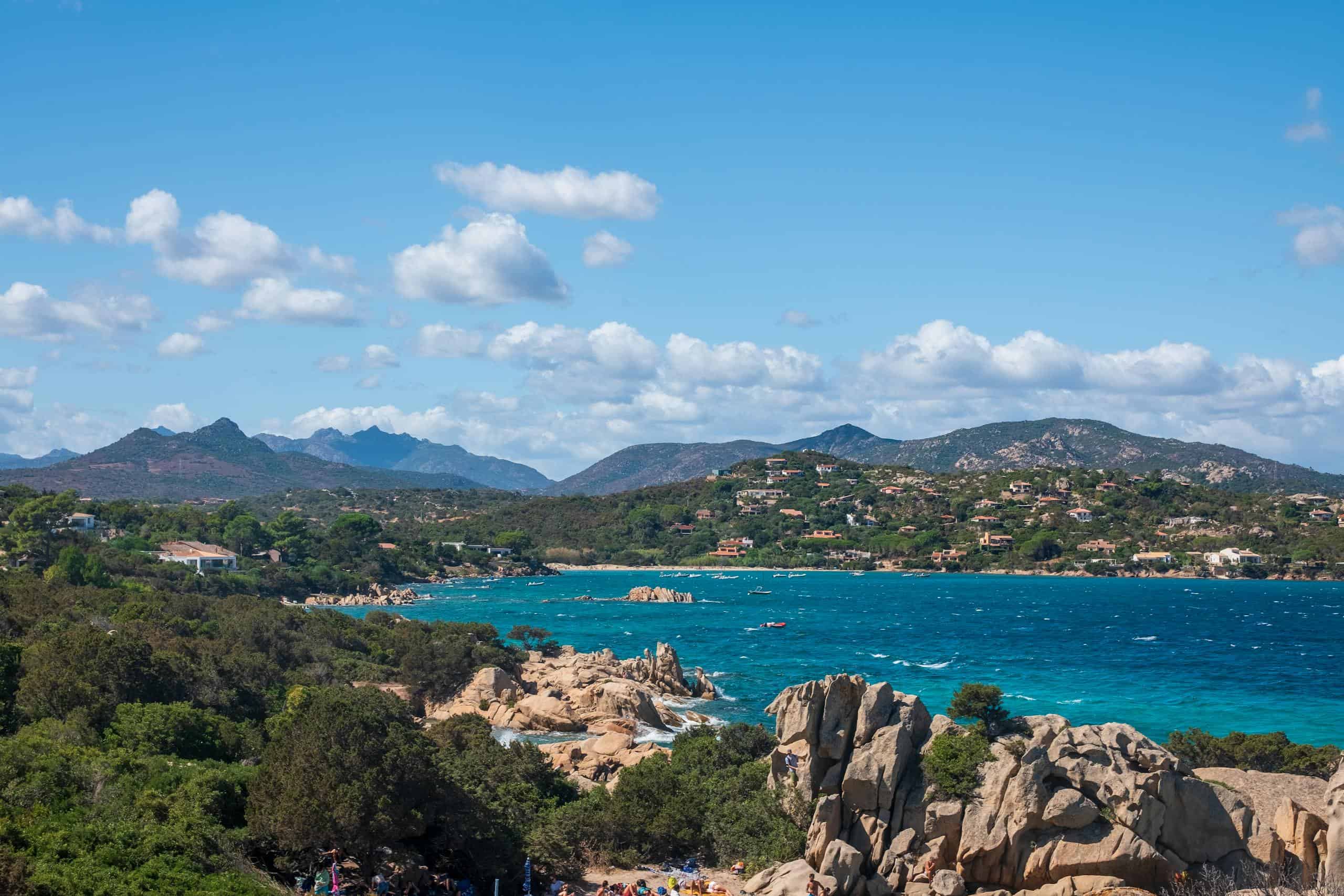 Breathtaking view of Sardinia's rugged coast with deep blue sea and lush greenery.