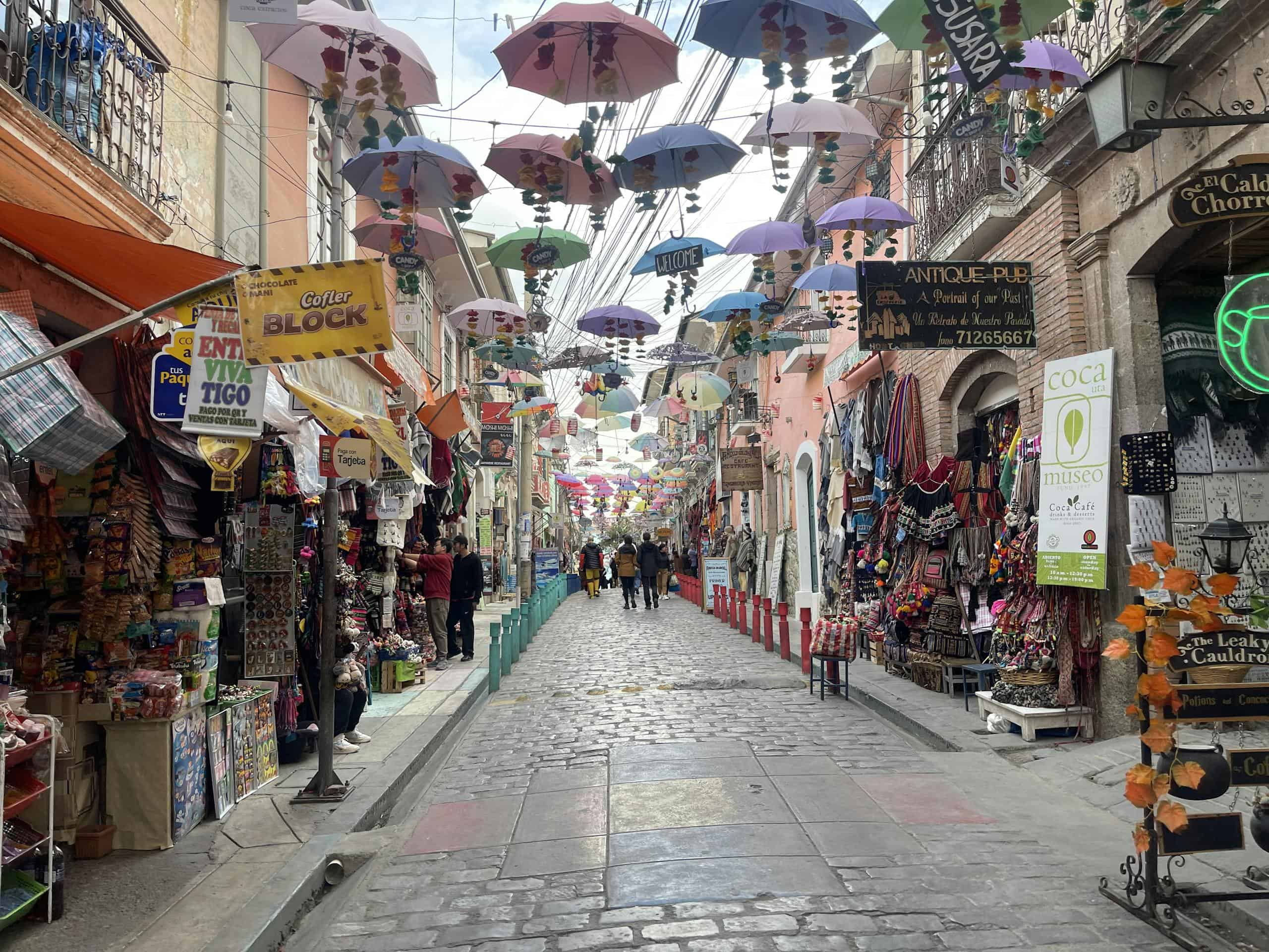 Colorful umbrellas decorate a bustling market street in La Paz, Bolivia.