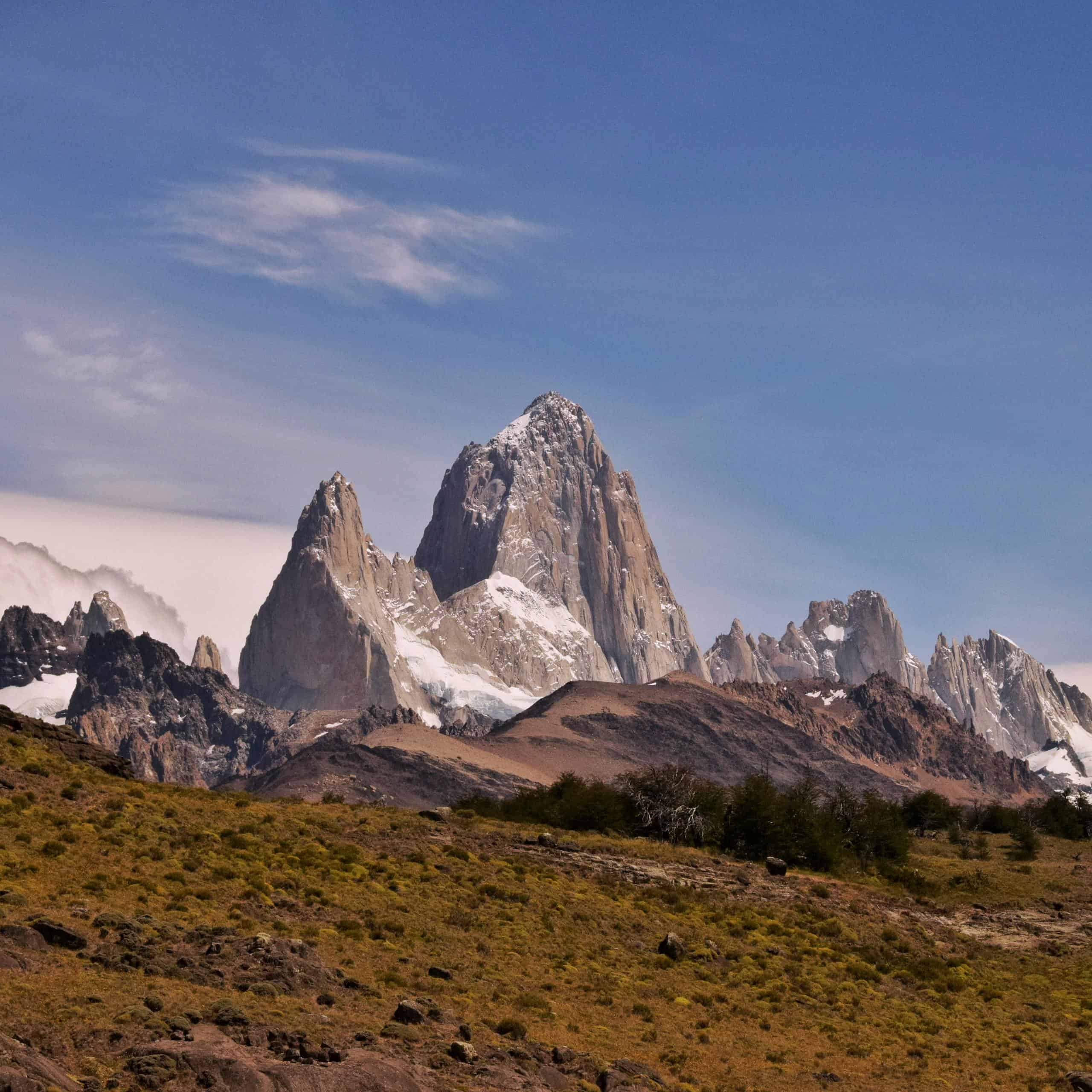 Scenic view of Mount Fitz Roy with snow-capped peaks under clear blue sky.