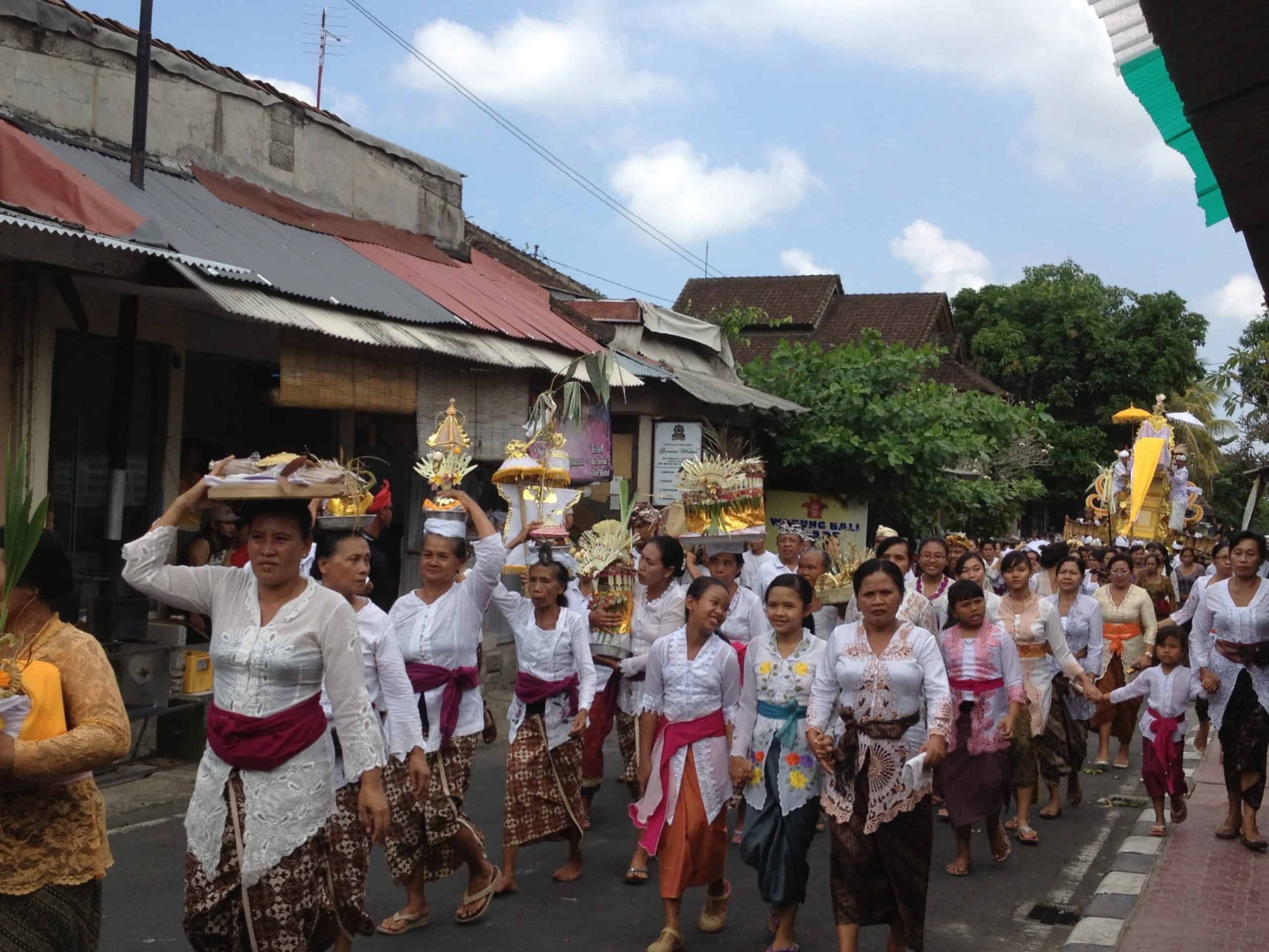 Balinese women lead a funeral procession in the streets of Ubud; a cultural celebration of life.