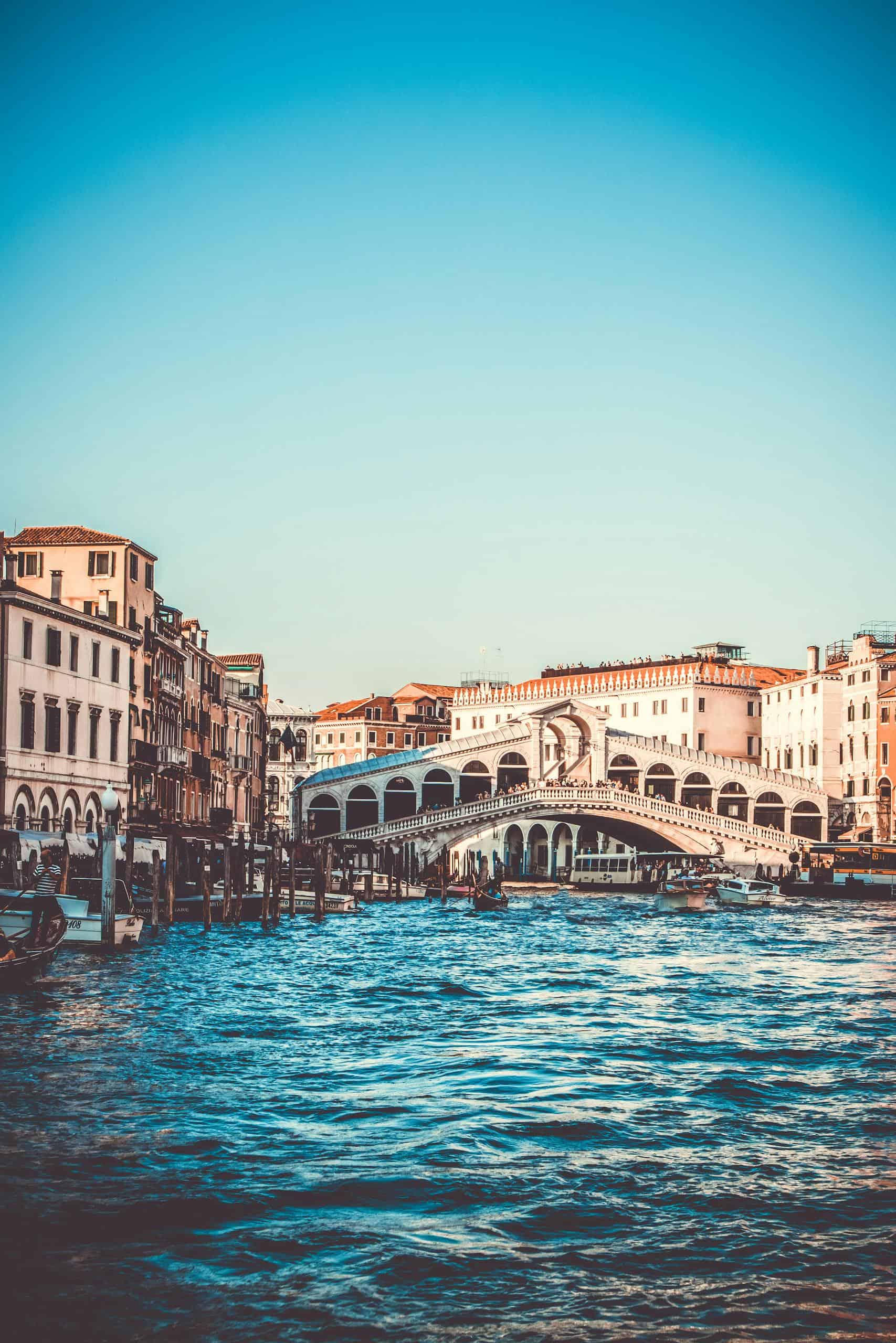 Explore the iconic Rialto Bridge over the Grand Canal in Venice, a must-visit tourist spot.