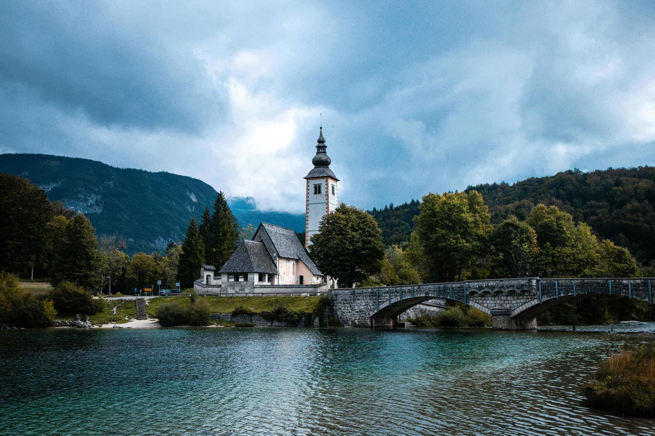 Picturesque view of St. John the Baptist Church and bridge over Lake Bohinj in Slovenia.